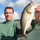 Un pescador muestra un buen ejemplar de black bass o perca negra.