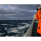 Un marine australiano otea el horizonte en el océano Índico en busca de algún rastro del avión desaparecido de Malaysia Airlines.