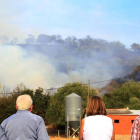 Vecinos contemplan las maniobras de los efectivos en la zona afectada por el incendio.