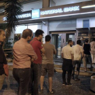 Ciudadanos griegos hacen cola ante el cajero del Banco Nacional de Grecia, en Atenas, esta madrugada.