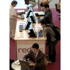 Varias personas navegan por Internet en un espacio equipado con varios ordenadores.