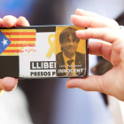 Imagen de una independentista con un carnet de Puigdemont, el miércoles, en una manifestación a las puertas de la Generalitat. ALEJANDRO GARCÍA