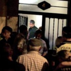 Policías, familiares y vecinos aguardan la retirada de los cadáveres.