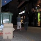 Varias cajas de cartón, apiladas junto a un contenedor en la calle del Padre Miguélez