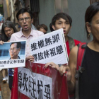 Varios seguidores del alcalde de la localidad meriodional de Wukan, Lin Zuluan, sostienen pancartas y protestan de camino a la oficina china Liaison en Hong Kong.