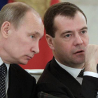 Vladimir Putin escucha al presidente ruso, Dmitri Medvedev, el lunes, en una reunión en el Kremlin.