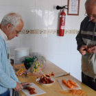 Ramón Herguedas prepara la comida en el albergue junto a un peregrino.