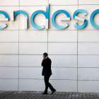 Un hombre camina bajo el logo de Endesa en la sede de la empresa en Madrid