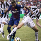 Neymar intenta zafarse de dos futbolistas de la Juventus en el amistoso del domingo. EDU BAYER