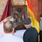 Unos vecinos observan el escudo antes de que se instalara en su lugar.
