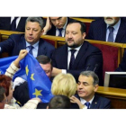 Diputados opositores esgrimen una bandera europea ante Azárov (derecha) y sus ministros en la Rada, este viernes en Kiev.