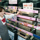 Una vendedora muestra reproductores de VHS de alta calidad en Japón.