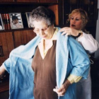 Una anciana es ayudada por una enfermera integrante del servicio de asistencia a domicilio