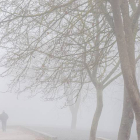Una pareja pasea entre la niebla. DAVID AGUILERA