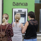 Usuarios de Bankia utilizan un cajero de la entidad en Barcelona.