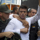 El dirigente opositor venezolano Leopoldo López se entrega a miembros de la Guardia Nacional en febrero de 2014.