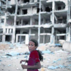 Una niña palestina junto un bloque de casas destruido en el norte de la franja de Gaza.