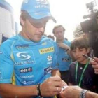 Fernando Alonso, firmando autógrafos, se muestra confiado en Monza