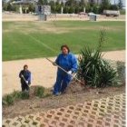 Dos trabajadoras limpian el talud de la zona del polideportivo