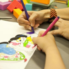 Unos niños coloreando un dibujo de Disney en una imagen de archivo.