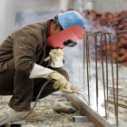 Un trabajador suelda unos hierros en una fábrica en construcción. M. REYNOLDS