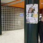 Un paciente espera apoyado en una columna con el cartel de la huelga
