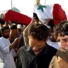 Dos jóvenes iraquíes lloran a sus muertos tras el triple atentado perpetrado ayer el Bagdad
