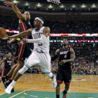 En el centro de la imagen, Rajon Rondo de los Celtics lucha por la pelota contra Shane Battier de los Heat de Miami en la prórroga del partido.