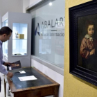 Un trabajador de la casa de subastas Abalarte manipula el óleo atribuido a Velázque 'Retrato de una niña'.