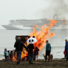 Vecinos de la localidad de Nome, en el mar de Bering, observan a lo lejos del crucero 'Crystal Serenity'. Las hogueras se encienden para dar calor a los bañistas que salen de las gélidas aguas.