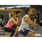 Varios usuarios de un gimnasio del centro de Barcelona se ponen en forma.