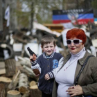 Un niño con una pistola de juguete y una mujer posan ante una barricada en la localidad ucraniana de Slaviansk, este jueves.