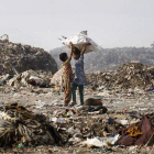Dos niños buscan material reciclable en un vertedero de India.