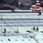 Un helicóptero de rescate sobrevuela el casco del crucero.