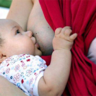 Una mujer, dando el pecho a su bebé.