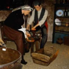 Dos de las figuras, haciendo chorizos en el interior de esta «casa del humo» recreada