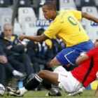 El jugador egipcio Ahmed Hassan frente al brasileño Luis Fabiano.