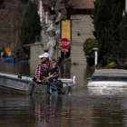 Pobladores intentan salir de una calle inundada en un poblado de California, EEUU.