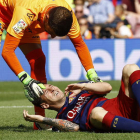 Leo Messi es atendido por el portero de Las Palmas, Javi Varas, tras lesionarse la rodilla.