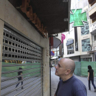 Un hombre lee el cartel de cierre de una de las farmacias de Ciudad Real.