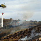 Las descargas de agua de un helicóptero ayudaron a controlar ayer el incendio en la linde del Camino de Santiago en El Acebo. BARREDO