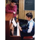 En la imagen un niño de educación primaria aprende a tocar el piano