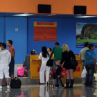 Varias personas chequean sus documentos para abordar un vuelo hacia Miami.
