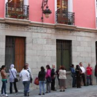 Personas que aguardaban ayer en la cola para solicitar ayuda en la nueva sede de Cáritas León, en la