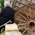 Una mujer anciana descansa sentada junto a un carro y su muleta. JESÚS F. SALVADORES