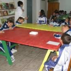 Un grupo de niños asisten a una clase en un aula que simula lo que sería una clase ecuatoriana