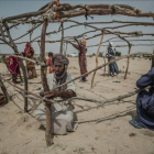 Un grupo de desplazados construye una cabaña en el asentamiento de Manara.