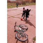 Tres niños dejan la bici para jugar al fútbol en Santa Marina del Rey
