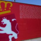 Panel con el escudo de León colocado en la sede de las Cortes de Castilla y León durante una exposición temporal.