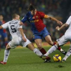El defensa del FC Barcelona Carles Puyol (c) conduce el balón ante Cannavaro y Guti del Real Madrid